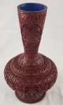 China. Imponente vaso em laca vermelha, ricamente ornamentado em alto-relevo com delicados motivos florais e arabescos, com corpo bojudo e pescoço alongado, Interior em azul contrastante, com etiqueta original de procedência. Medindo: 39 x 27 cm.  