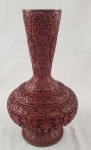 China. Imponente vaso em laca vermelha, ricamente ornamentado em alto-relevo com delicados motivos florais e arabescos, com corpo bojudo e pescoço alongado, Interior em azul contrastante, com etiqueta original de procedência. Medindo: 39 x 27 cm. 