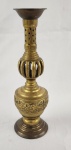Castiçal em bronze oriental, com corpo torneado e elementos vazados na haste, decorado com faixa em relevo de motivos ornamentais. Apresenta base circular escalonada e bocal superior em formato aberto. Pátina natural do tempo. Século XX. Dimensões: 24 x 7 cm. 
