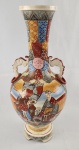 Elegante vaso em porcelana no formato ânfora, ao gosto Satsuma com bojo volumoso, colo alongado e alças laterais ornamentais. Ricamente decorado com cenas figurativas e padrões geométricos em policromia, com destaque para personagens e elementos inspirados na estética oriental. Medindo; 47 x 21 cm. 