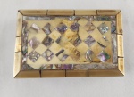 Delicada caixa porta-joias em formato retangular, ricamente revestida em madrepérola com belos reflexos iridescentes. Tampa decorada com entalhes e composição geométrica, evidenciando trabalho artesanal de inspiração oriental. Interior forrado em tecido. Medindo: 4 x 12 x 7 cm.