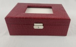 Porta-joias vintage com tampa em material sintético texturizado, imitando couro de crocodilo, em tom vermelho. Peça de formato retangular, com interior compartimentado e revestido em material aveludado claro, incluindo divisórias e suporte para anéis. Tampa com espelho interno e fechamento frontal metálico. Medidas: 10 x 28 x 19 cm. 