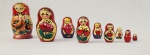 Boneca russa tipo matrioska em madeira, pintada à mão, composta por conjunto de 9 peças encaixáveis. Apresenta decoração policromada com figura feminina estilizada e motivos florais. Medidas: 10 x 5 cm (peça maior). 