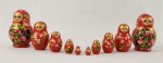 Boneca russa tipo matrioska em madeira, pintada à mão, composta por conjunto de 10 peças encaixáveis. Apresenta decoração policromada com figura feminina estilizada e motivos florais. Medidas: 8 x 3 cm (peça maior).