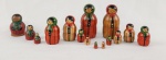Conjunto de bonecas tipo matrioska em madeira, pintadas à mão, composto por 15 peças encaixáveis. Apresenta decoração policromada com figuras estilizadas e inscrição `Made in Poland` na base. Medidas: 9 x 3 cm (peça maior). 