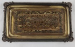 Bandeja decorativa em metal, de formato retangular, com bordas trabalhadas em relevo e alças laterais integradas. Fundo com rica decoração em arabescos e motivos geométricos em policromia, com influência oriental. Medidas: 32 x 18 cm.