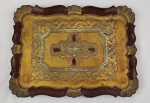 Bandeja veneziana decorativa em madeira, de formato retangular com bordas recortadas, ricamente ornamentada com pintura policromada e motivos arabescos em baixo relevo. Apresenta composição central decorativa com influência clássica, em tons dourados, avermelhados e detalhes em verde. Medidas: 35 x 26 cm. 