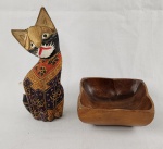 Lote composto por escultura decorativa em madeira representando gato estilizado, com pintura policromada, e petisqueira em madeira de formato orgânico, com acabamento liso. Medidas: escultura aprox. 20 cm; petisqueira 13 x 9 cm.