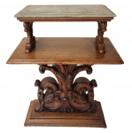 Coluna/ base / mesa auxiliar antiga em madeira entalhada, apresentando base central ricamente ornamentada com volutas e elementos vegetalistas, sustentando prateleira intermediária e tampo superior em mármore. Medidas: 60 x 50 x 35 cm. Tampo de mármore: 42 x 27 cm.