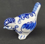 Escultura decorativa em porcelana representando pássaro, com decoração em azul e branco em padrão floral, de inspiração oriental. Apresenta acabamento esmaltado e rica ornamentação.  Medidas: 10 x 14 cm.