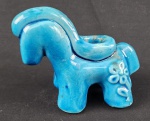 Peça decorativa em cerâmica esmaltada na tonalidade azul, em formato estilizado de cavalo, com abertura superior podendo ser utilizada como pequeno vaso ou castiçal. Apresenta detalhes em relevo no corpo. Medidas: 10 x 13 cm.
