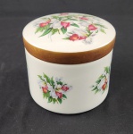 Pote decorativo com tampa em porcelana esmaltada, de formato cilíndrico, decorada com motivos florais policromados na tampa e no interior. Medidas: 10 x 12,5 cm