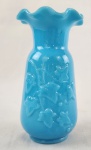 Vaso decorativo em opalina azul-turquesa, com corpo ornamentado por motivos vegetais em relevo e borda ondulada.. Altura: 12 cm.