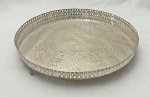 Grande salva / centro de mesa em metal espessurado a prata, com galeria fenestrada e fino trabalho de gravação com motivos florais e arabescos ao gosto clássico. Apoiada sobre 3 pés, um deles com restauro. Medindo: 41 cm.