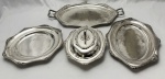 Wolff. Baixela em metal espessurado à prata, com borda decorada. Composto de bandeja, travessa oval, travessa redonda e legumeira. Medindo: 51 x 33 cm, 40 x 29 cm, 31,5 cm e 13 x 29 x 23 cm.