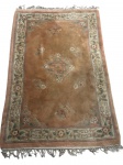 Tapete oriental em lã, de origem chinesa, apresentando decoração floral e medalhão geométrico central em policromia suave sobre fundo rosê. Medindo; 175 x 120 cm