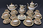 Rio Branco - Conjunto para chá e café em porcelana na cor branca, detalhes em furta cor, listra na cor vinho e ricos detalhes em ouro. Sendo bule para chá, café, leiteira, açucareiro, manteigueira, seis xícaras para chá e seis para café. Manufatura no verso. Medindo respectivamente: 15 x 22 cm, 21 x 21 cm, 13 x 14 cm, 11 x 15 cm e 8 x 14 cm.