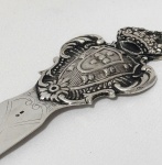 PRATA. Abridor de cartas em prata de lei contrastada, cabo ricamente cinzelado em relevo com o Brasão de Armas de Portugal coroado e ornamentação em volutas, florões e motivos vegetalistas. Lâmina lisa com delicada gravação ornamental. Medidas: 22 cm de comprimento. Peso: 42 gramas.