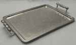Belíssima bandeja em metal prateado com parte central ricamente cinzelada. Medindo: 5 x 33 x 48 cm.