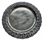 Antiga salva em metal espessurado a prata, centro ricamente gravado com exuberante composição floral em finíssimo trabalho de buril. Borda amplamente vazada, executada em delicado rendilhado de volutas, arabescos e motivos vegetalistas de inspiração Rococó. Medidas: 33 cm de diâmetro.