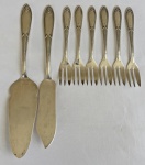 Eberle. Conjunto para sobremesa em metal espessurado a prata, composto por uma pá para torta, uma faca e seis garfos para sobremesa, com cabos no estilo Art Déco. Apresenta leves marcas do tempo.