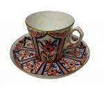 Antiga xícara de coleção em porcelana, decoração no tradicional padrão Imari, ricamente ornamentada com reservas geométricas e motivos florais policromados em tons de azul-cobalto, vermelho-ferro e dourado, com delicados filetes a ouro. Manufatura na base.