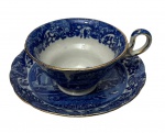 Antiga xícara de coleção em porcelana inglesa, decorada no padrão Blue Willow, com rica estampa em azul-cobalto representando paisagem oriental, pagodes, ponte, embarcações e vegetação. Bordas delicadamente filetadas a ouro. Manufatura na base.