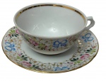 Vista Alegre, Portugal. Antiga xícara de coleção para chá em porcelana portuguesa esmaltada e policromada, ricamente decorada com delicados ramalhetes florais, laços e arabescos em douração sobre fundo branco. Bordas filetadas a ouro. Manufatura marcada no verso.
