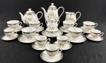 Steatita. Serviço para chá e café em porcelana esmaltada e policromada, decorado com motivos florais e frisos em ouro. Composto por bule para café, bule para chá, leiteira, açucareiro, manteigueira, 6 xícaras para chá com seus respectivos pires e 5 xícaras para café com seus respectivos pires. Medidas: bule para café 20 x 20 cm; bule para chá 15 x 20 cm; leiteira 12 x 14 cm; açucareiro 11 x 11 cm; manteigueira 8 x 15 cm. BIco do bule para chá apresenta quebra.