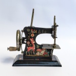 Brinquedo Antigo - Mini máquina de costura em chapa com litografia infantil em policromia, produzida pela fábrica de brinquedos ESTRELA. Década de 1950. Med 14 x 14 cm aproximadamente.