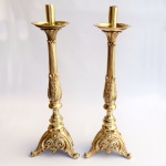 Arte Sacra - Par de antigos castiçais litúrgicos em bronze polido com rica ornamentação de folhagens e volutas sobre base trípode. Med 51 cm. 