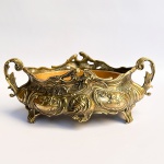 Antiga Floreira em bronze com riquíssimo trabalho de flores e volutas em alto relevo sobre pés e com alças nas laterais. Acompanha recipiente interno. Med 31 x 18,5 x 12,5 cm. 