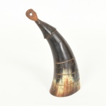 MILITARIA, um (1) antigo Polvorinho (pequeno recipiente utilizado para transportar, proteger e medir a quantidade de pólvora negra necessária para municiar arma de fogo de carregamento pela boca, dita soca soca, como: mosquetes e bacamartes), confeccionado em chifre, cheio de esferas em chumbo de diversos tamanhos, medindo 17,5 cm altura, sinais de uso, vide foto.