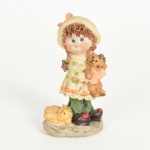 ESCULTURA, uma (1) figurativa representando menina segurando urso de pelúcia com gato ao lado da perna, confeccionada em resina, policromada, medindo 11,5 cm altura, vide foto.