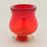 VIDRO, um (1) vaso bojudo de pé baixo, bojo na tonalidade vermelha, base incolor, translúcido, mossa acentuada no bojo, medindo 11,5 cm altura, sinais de uso, vide foto.