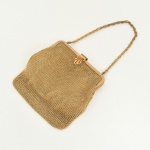 ACESSÓRIO FEMININO, uma (1) antiga bolsa de festa, confeccionada em malha dourada, alça curta, parte interna com forração em cetim, possui manchas, acompanha espelho dupla face, medindo 12 x 13 cm, sinais de uso, vide foto.