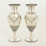 PRATA PORTUGUESA, par (2) vasos floreiros no formato de balaustre, corpo cinzelado com guirlandas de flores e folhas, base e borda em perolados, puncionados: Águia 833 e marca do ourives, medindo 17 cm altura, peso total aproximado 321 gr., vide foto.