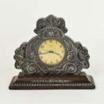 RELÓGIO, um (1) antigo de mesa, cornija ou estante, marca CYMA (fundada em 1862 pelos irmãos Joseph Schwob e Theodore Schwob na Suíça; em 1892 associaram-se a Henri Sandoz & Cie Empresa Atacadista de relógios, tornando-se CYMA WATCH Co.; atualmente é propriedade de STELUX INTERNATIONAL Ltd.), despertador, gabinete em jacarandá, apliques em PRATA com contrastes não identificados, usado, funcionando e sem garantia, vide foto.