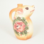 FAIANÇA, uma (1) garrafa com tampa, modelada na forma de porco, pintada a mão com florais em policromia, marca pintada a mão IMPERIAL (possivelmente São Paulo, anos 50/60 ou até mesmo Itaipava, RJ do mesmo período), medindo 21 cm altura, vide foto.