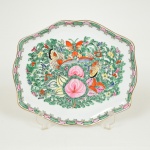 PORCELANA CHINESA, uma (1) bandeja quase oval com borda chanfrada, ornamentação pintada a mão, dito Família Rosa com borboletas, volutas e elementos vegetalistas, padrão Cantão, arremates a ouro, marca em caracteres no verso, medindo 24 x 21 cm, vide foto.