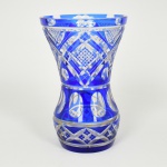 CRISTAL OVERLAY, um (1) vaso floreiro na tonalidade azul sobre incolor, translúcido, lapidação dedão, sulcos e geométricos, fundo estrelado, apresenta diversos quebrados e colados, medindo 21,5 cm altura, vide foto.