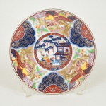 PORCELANA ORIENTAL, um (1) prato decorativo, ornamentação pintada a mão em policromia, padrão IMARI, representando edificações, salgueiro, fênix, além de elementos geométricos e vegetalistas, sem marca de manufatura aparente, medindo 20,5 cm diâmetro, vide foto.
