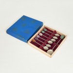 METAL PRATEADO, conjunto para café com sete (7) itens: 1 concha e 6 colheres, cabo em torçaide, extremidades com pedras irregulares, semi preciosas de quartzo verde e rosa, ametista e ágata, medindo a maior peça 13,5 cm comprimento, acondicionados em caixa de papel cartonado, vide foto.