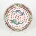 PORCELANA CHINESA, um (1) prato decorativo com ornamentação policromada representando dragões celestiais nas nuvens, borda com barrado de flores, pássaros e geométricos, marca em caracteres no verso, medindo 26 cm diâmetro, vide foto.