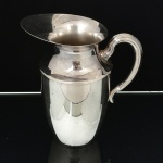 METAL PRATEADO, um (1) gomil liso, alça curvilínea, marca WOLFF (tradição desde 1894), medindo 20 cm altura, sinais de uso, vide foto.