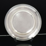 METAL PRATEADO, uma (1) travessa circular da renomada marca francesa CHRISTOFLE, borda com marca possessória representada por monograma, medindo 32,5 cm diâmetro, sinais de uso, vide foto.