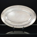METAL PRATEADO, uma (1) travessa oval da renomada marca francesa CHRISTOFLE, borda com marca possessória representada por monograma, medindo 51 x 33 cm, sinais de uso, vide foto.