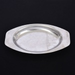 AÇO INOX, uma (1) travessa quase oval com extremidades chanfradas, marca ELMO (marca fantasia usada na década de 50 pela Indústria Metalúrgica Gazola S/A, fundada em 1932 por José Gazola, no Rio Grande do Sul, RS, fechou em 2009), apresenta riscos e sinais de uso, medindo 30 x 16,5 cm, vide foto.
