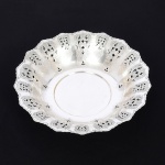 METAL PRATEADO, uma (1) fruteira circular com borda recortada e vazada em elementos vegetalistas, sem marca de manufatura aparente, medindo 29,5 cm diâmetro e 6 cm altura, sinais de uso, vide foto.