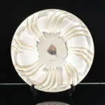 METAL PRATEADO, uma (1) fruteira circular, borda plissada em espiral, base trípode em esferas, marca WOLFF (tradição desde 1894), medindo 29,5 cm diâmetro, sinais de uso, vide foto.
